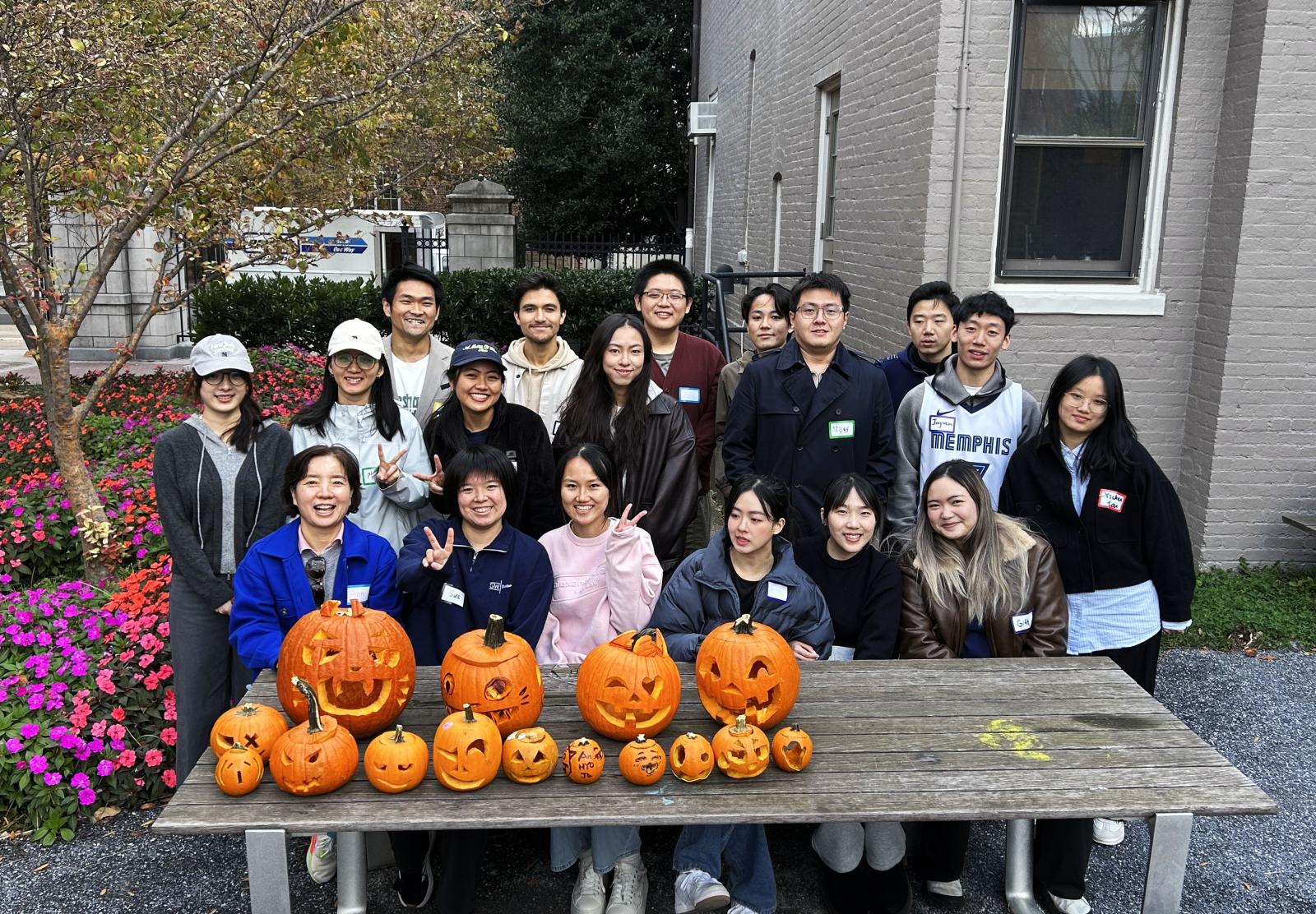 Group of GWU students posing with their pumpkins, carved for Halloween.