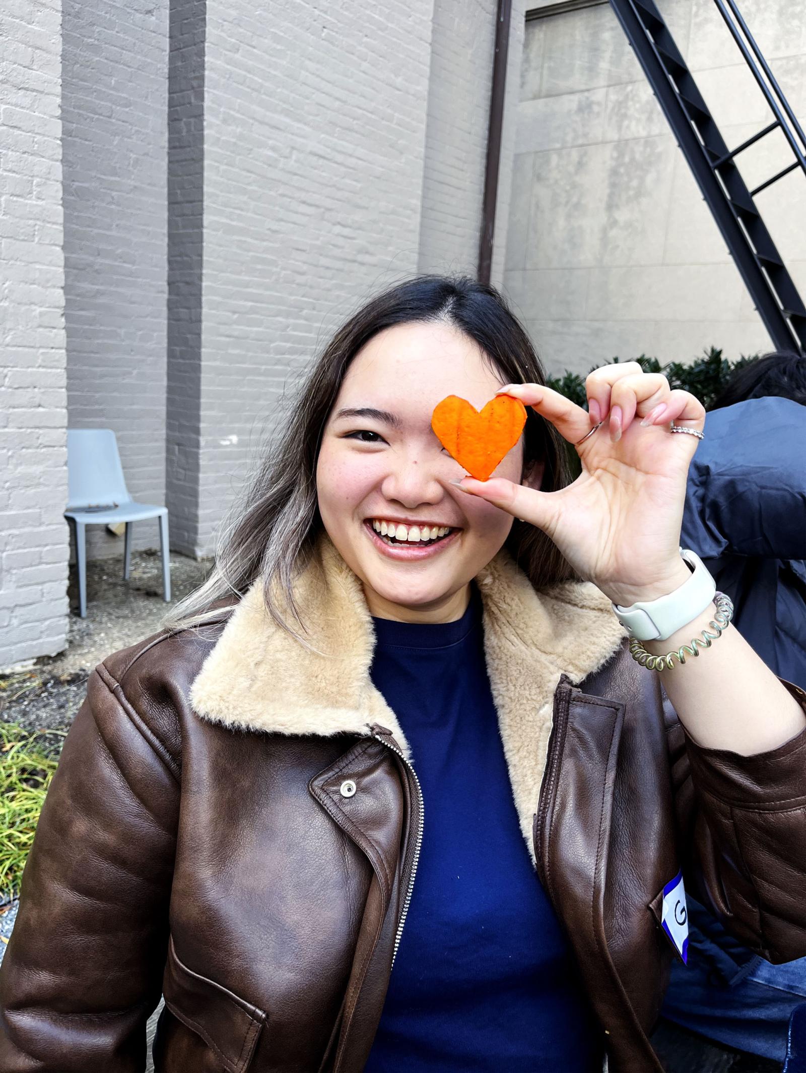 A GWU student poses with a pumpkin piece.
